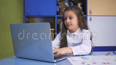 在图书馆学习的女孩用笔记本电脑做课后作业。 有设备的小学。 儿童